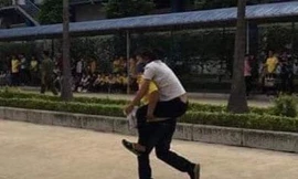 Một công nhân bị ngộ độc được đồng nghiệp cõng đi cấp cứu - Ảnh: Hoàng Long