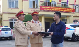 Đại diện Phòng CSGT, Công an tỉnh Hà Nam trao trả tài sản cho người đánh rơi - Ảnh: Công an Hà Nam