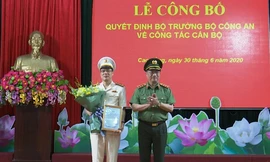 Đại tá Vũ Hồng Quang (bìa trái) nhận Quyết định, hoa chúc mừng từ lãnh đạo Bộ công an .Ảnh: G. Hưng