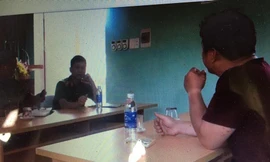 Lực lượng chức năng huyện Bình Gia làm việc với "nhà ngoại cảm" L (bên phải) tại xã Mông Ân. Ảnh: TL