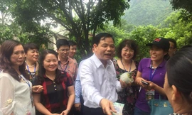 Bộ trưởng Nguyễn Xuân Cường mua na của người dân địa phương. - Ảnh: Hoàng Dự 