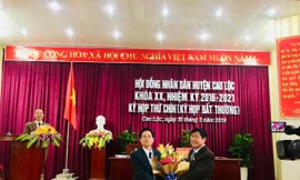 Ông Nguyễn Duy Anh (bìa trái) nhận hoa chúc mừng của lãnh đạo Huyện ủy Cao Lộc .Ảnh: Duy Chiến