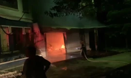 Lực lượng chức năng nỗ lực ngăn cản không cho ngọn lửa cháy sang ngôi biệt thự bên cạnh .Ảnh: Duy Chiến