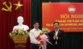 Ông Nông Lương Chấn (bìa trái) nhận hoa chúc mừng của lãnh đạo tỉnh ủy Lạng Sơn *ảnh: Hoàng Huấn