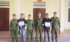 Hai đối tượng Thái và Đại (cầm biển) bị lực lượng biên phòng Tân Thanh bắt giữ khi đưa người qua biên giới trái phép .Ảnh: Duy Chiến 