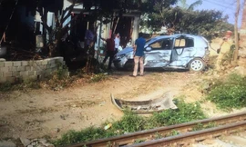 Chiếc xe ô tô bị tàu hỏa đâm, văng hàng chục mét ven đường .Ảnh: Duy Chiến