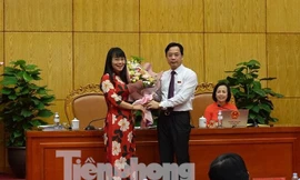 Chủ tịch HĐND tỉnh Lạng Sơn (bìa phải) tặng hoa chúc mừng bà Trần Thị Sơn Thùy .Ảnh: DC