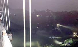 Lực lượng cứu hộ trục vớt chiếc xe ô tô lao xuống sông.