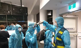 Đo thân nhiệt hành khách trước khi lên máy bay tại Úc, toàn bộ hành khách và tổ bay đều mặc trang phục bảo hộ y tế.