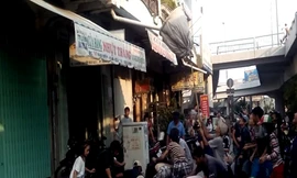 Dùng vợt tự chế để tranh cướp đồ cúng cô hồn. Ảnh: Khánh Ly.