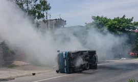 Chiếc xe lật nghiêng và bốc khói nghi ngút (Ảnh: Dân trí)