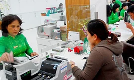 Khách hàng đang giao dịch tại một ngân hàng ở TP.HCM. Ảnh: HTD