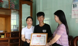 Cô giáo Nguyễn Thị Liên, hiệu trưởng trường THPT Nguyễn Bỉnh Khiêm trao giấy khen cho hành động dũng cảm của học sinh Cao Anh Vũ.