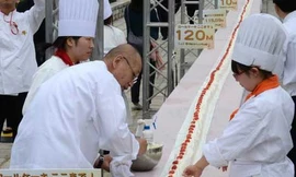 90 sinh viên cùng thợ làm bánh đang hoàn thành chiếc bánh