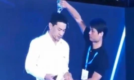 Ông Robin Li Yanhong bị người mặc áo đen đổ chai nước xuống đầu. (Ảnh: SCMP)