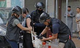 Cảnh sát Hong Kong kiểm tra túi của một người biểu tình. (Ảnh: AP)