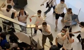 Nhóm côn đồ mặc áo trắng dùng gậy sắt tấn công người dân Hong Kong tại một ga tàu điện ngầm vào cuối tuần trước. (Ảnh: SCMP)