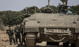 Lính Israel đứng cạnh một chiếc xa tăng gần biên giới Israel Gaza. Ảnh: AP