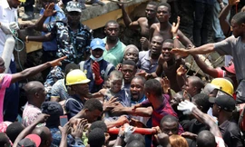 Một trẻ em được cứu thoát khỏi đống đổ nát của tòa nhà bị sập. Ảnh: Reuter