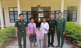 Đại diện Đồn Biên phòng Nhơn Hưng, BĐBP An Giang trao tặng xe đạp cho em Sôn Sun Ly. Ảnh: Chiến Khu