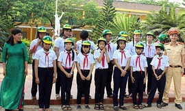 Trao mũ bảo hiểm đạt chuẩn cho các em học sinh giải đáp đúng về an toàn giao thông với trò chơi đố vui “Trả lời đúng, trúng quà”