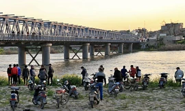 Người dân và người nhà nạn nhân chờ đợi trên bờ sông Tigris sau vụ tai nạn chìm phà. Ảnh: AP.