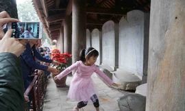 Cha mẹ khuyến khích con cái vượt rào sờ đầu rùa lấy may, mặc bảo vệ nhắc nhở tới nơi tới chốn. Ảnh: Nguyên Khánh