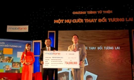 Ông Mai Văn Bình, Tổng Giám đốc MobiFone, trao 734 triệu đồng tiền bán vé Rockstorm cho ông Grey McFall, Phó Chủ tịch ban cố vấn Operation Smile Việt Nam