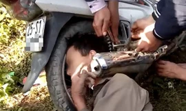 Giải cứu người đàn ông kẹt đầu giữa bánh và bô xe máy