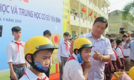 Bộ trưởng GTVT Đinh La Thăng tặng mũ cho học sinh tại buổi lễ