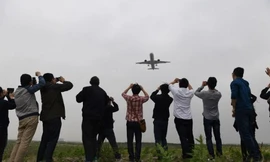 Người dân Trung Quốc thích thú chụp ảnh chiếc máy bay chở khách đầu tiên mang tên Comac C919 do nước này tự sản xuất trong chuyến bay thử nghiệm hôm 5/5 ở sân bay Pudong, Thượng Hải.