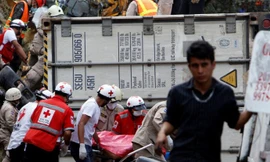 Các nhân viên cứu hộ gấp rút đưa người bị nạn đi cấp cứu.