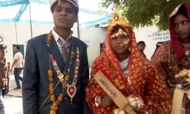 Một cô dâu nhận cây gậy gỗ từ Bộ trưởng trong ngày cưới hôm 29/4.