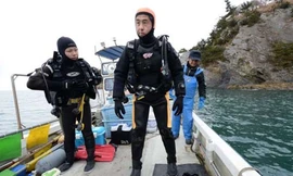 Ông Takamatsu chuẩn bị lặn xuống biển trước ngày kỷ niệm ba năm thảm họa kép ở Nhật Bản vào năm ngoái. Ảnh: AFP.