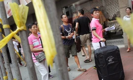 Khách du lịch Trung Quốc đi qua khu vực biểu tình tại Causeway Bay ngày hôm qua (Ảnh: SCMP)