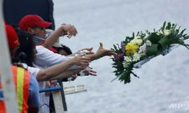 Người thân ném hoa tưởng nhớ các nạn nhân. 