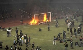 CĐV CLB Persebaya Surabaya đốt cầu môn và biển quảng cáo trên sân Gelora Bung Tomo - Ảnh: Bola