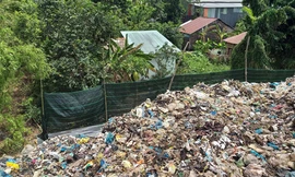 Bãi rác ở thị trấn Kinh Cùng đang tấn công nhà dân. Ảnh: Kim Hà