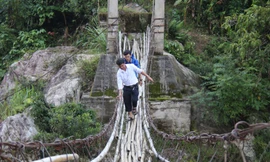 Các thầy giáo trường Phổ thông Dân tộc bán trú tiểu học và trung học cơ sở Sơn Bua thường xuyên vượt cầu “tử thần” vào làng vận động học sinh đến trường. Ảnh Nguyễn Ngọc