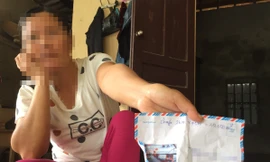 Số điện thoại cùng phong bì ghi số tiền gia đình em D. nhờ một người đi gửi cho một tài khoản ở Nghệ An. Ảnh: Hoài Nam 