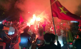 Cổ động viên xuống đường, đốt pháo sáng ăn mừng chiến thắng đội nhà. Ảnh: P.V
