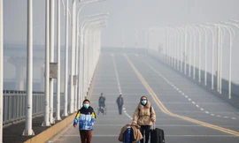 Một số người dân đi bộ qua cầu từ tỉnh Hồ Bắc sang Giang Tây hôm 31/1. Ảnh: Reuters