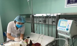 Điều dưỡng chăm sóc bé 3 tháng tuổi nhiễm virus hợp bào hô hấp phải thở oxy. Ảnh: Th. Hà