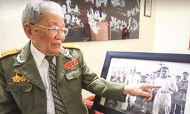 Đại tá Đoàn Sự bên tấm hình của mình phiên dịch cho Bác Hồ ở Bắc Kinh, Trung Quốc. Ảnh: Như Ý 