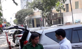 Nhân viên thu phí Nguyễn Văn Đức Vương hướng dẫn lái xe cài đặt phần mềm (app) trả phí trực tuyến khi đỗ xe trên đường Lê Lai (quận 1)