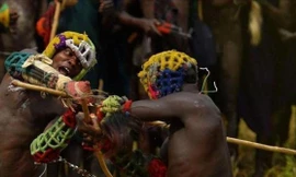 Các cô gái đứng xem các chàng trai vụt nhau bằng gậy