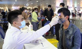 Đo thân nhiệt cho hành khách để kiểm soát dịch tại Cảng hàng không quốc tế Tân Sơn Nhất, TPHCM