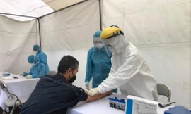 Lấy mẫu làm xét nghiệm tại điểm test nhanh ở trường THCS Đống Đa. Ảnh: H.M 