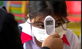 Một học sinh được kiểm tra nhiệt độ khi Campuchia mở cửa trở lại các trường học sau nhiều tháng ngừng hoạt động do COVID-19. Ảnh: Reuters