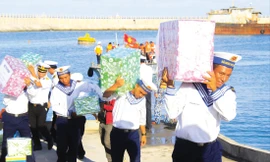 Các chiến sĩ vận chuyển quà tặng của đoàn công tác đến với Trường Sa. Ảnh: Trường Phong